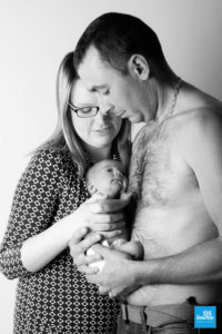Photo d'un nouveau né avec ses parents, en noir et blanc