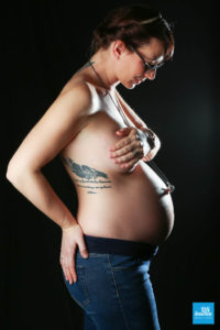 Photo d'une femme enceinte et de son ventre en shooting studio de grossesse