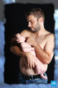 Papa et son bébé sur fond noir lors d'un shooting studio
