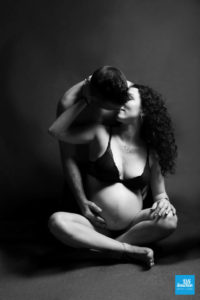 Photo de grossesse en noir et blanc sur fond noir