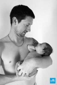 Photo studio d'un papa et son bébé en noir et blanc